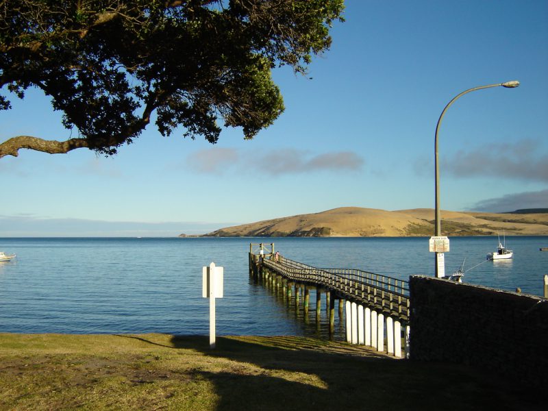 Looking across Hokianga Harbour towards sand dunes, with wharf in the foreground