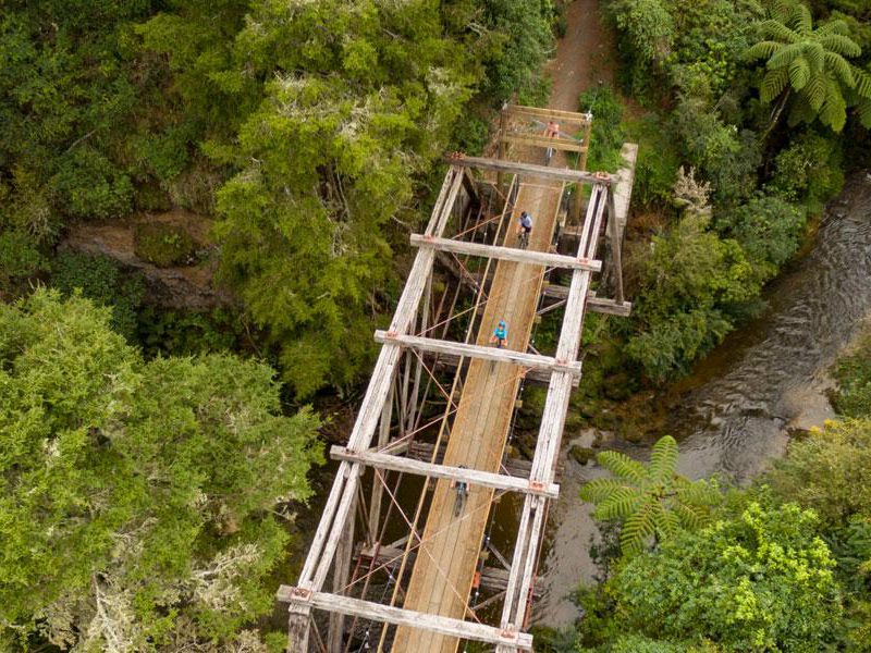 Aerial shot of person riding bike over wooden bridge